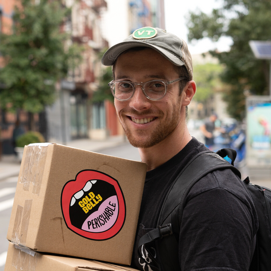 Chef Dave carrying a Goldbelly package for same-day shipping with a perishable sticker